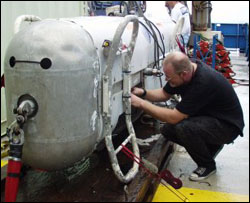 Woods Hole Deep Submergence Laboratory engineer, Jim Varnam, working on the DSL-120 vehicle equipped with side-scan sonars. Photo by Monte Basgall. Nicholas School of the Environment, Duke University.